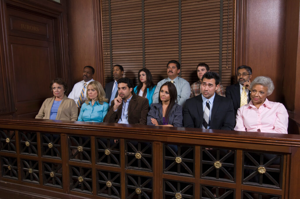 A panel of jury members sits listening to a criminal trial.